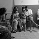 An Israeli family and neighbors sit in chairs and on the floor in a Jerusalem bomb shelter.