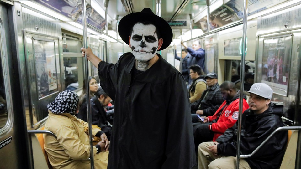 A man rides the subway dressed as a skeleton