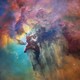 A colorful, dense cloud of dust and gas, backlit in part by hidden stars
