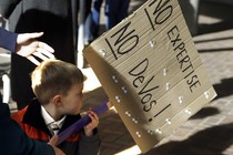 A 3-year-old boy carries a sign opposing Betsy DeVos`