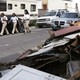 Students walk next to a pile of debris. 