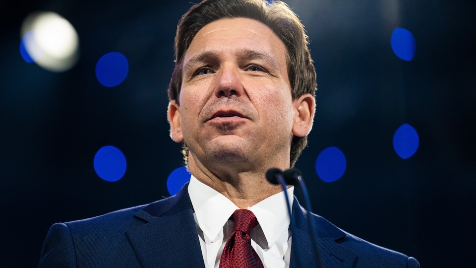 Ron DeSantis speaking to a microphone.