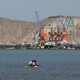 Boys sit on a piece of styrofoam sheet as they search for crabs in front of the Gwadar port in Pakistan.
