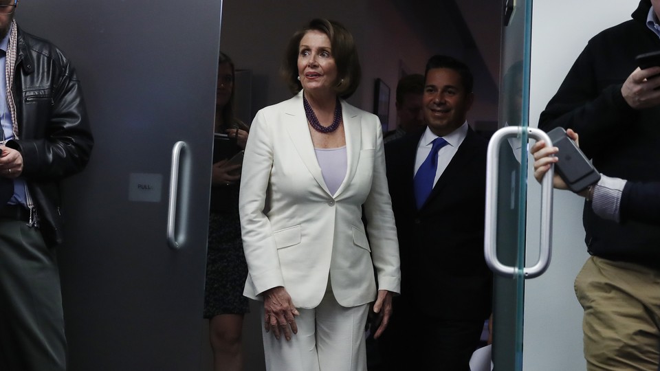 House Minority Leader Nancy Pelosi walks out of a building.