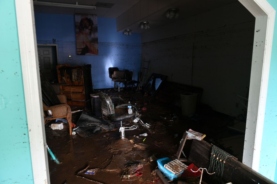 The dark, muddy interior of what appears to be a beauty salon, seen after the flood