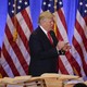 President-elect Donald Trump stands by a table covered with paperwork