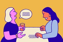 One woman talking while a woman opposite her scratches the table in irritation