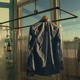 A shirt hanging in golden light before a big window showing a blue sky and a cityscape