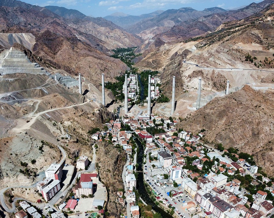 An aerial view of a village in a narrow valley in a mountainous area