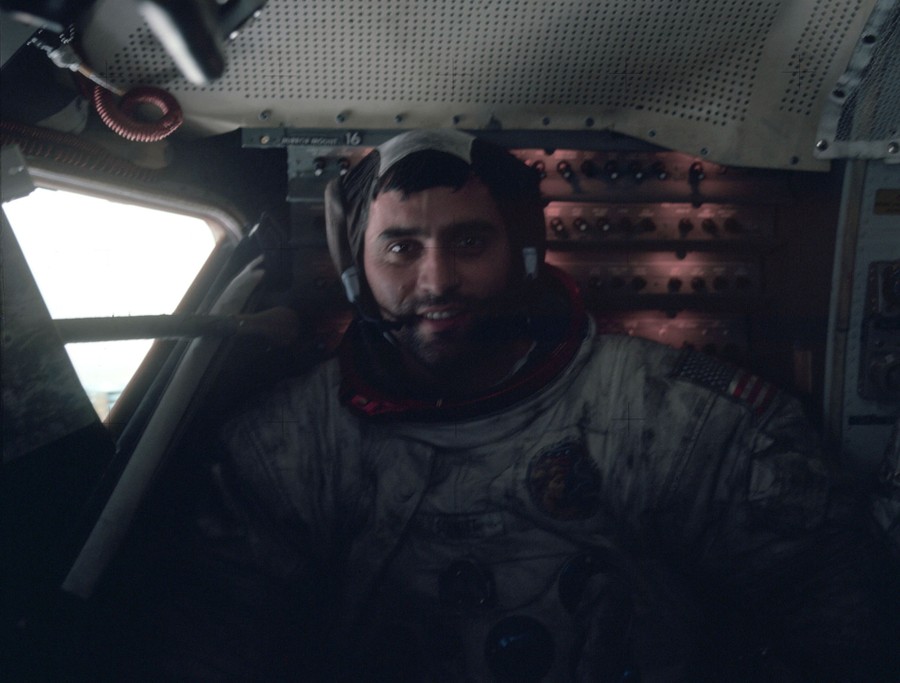 An astronaut poses inside a spacecraft.