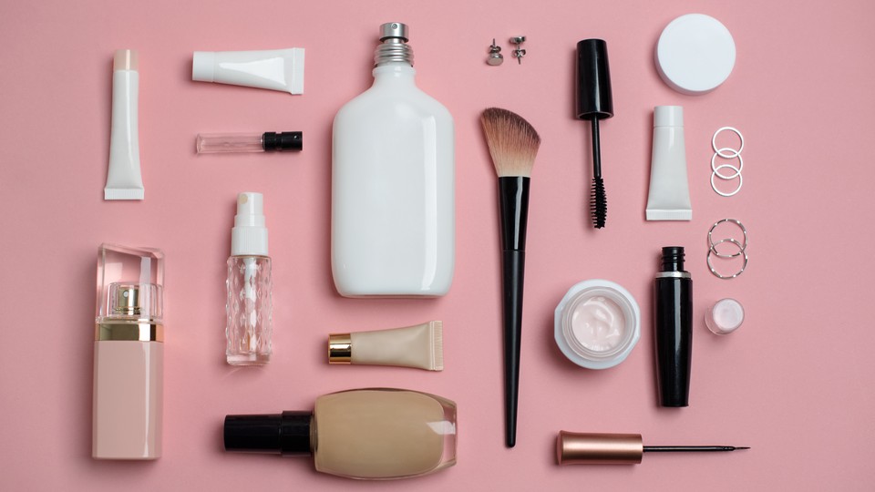 Numerous beauty products without labels arranged on a pink surface