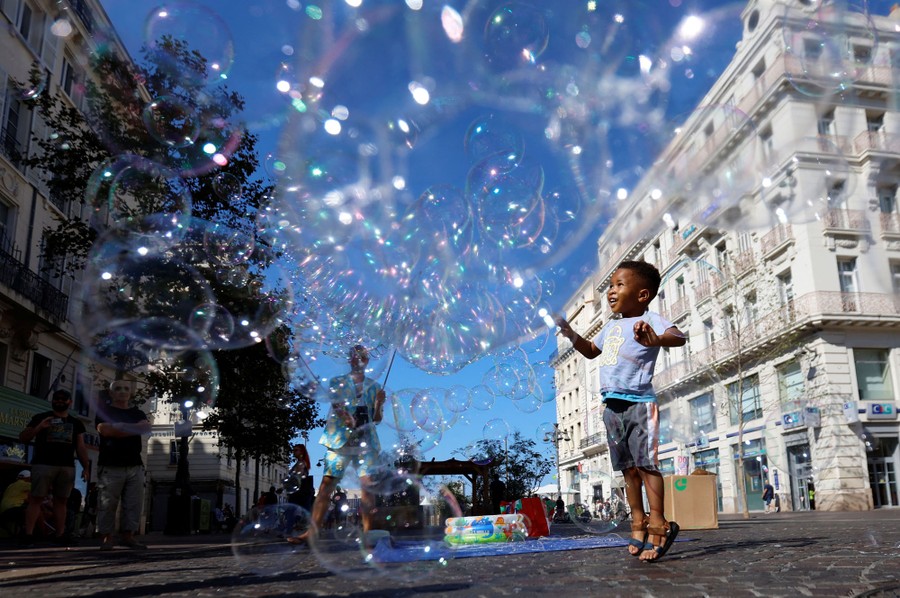 A child plays with bubbles from a street performer.