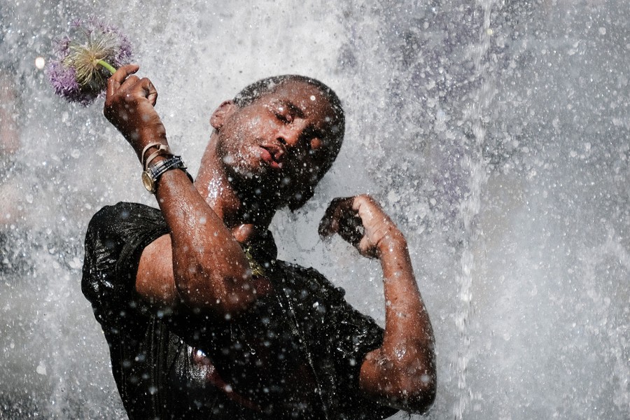 A person enjoys the water of a fountain.