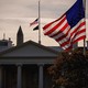 Photograph of an American flag flying above the White House