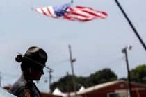 A state trooper stands next to a vehicle blocking a road leading to the event grounds in Butler, Pennsylvania.