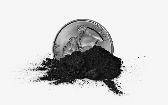 A quarter in a small pile of coal ash