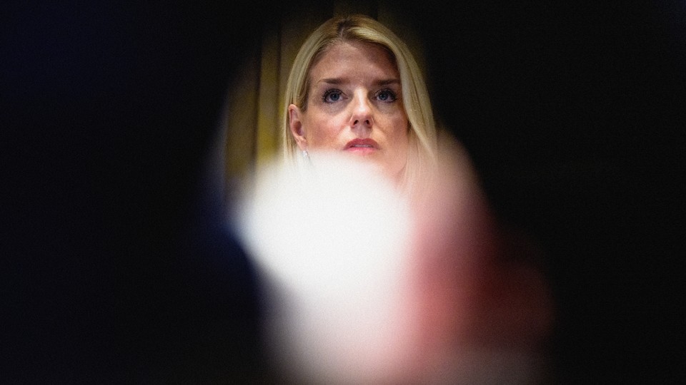 Photograph of Pam Bondi's face against a blurred black background.