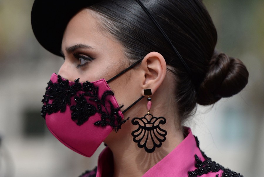 A woman wears a stylized mask while marching.