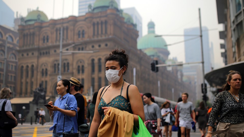 Pedestrians are seen wearing masks as smoke haze from bushfires in New South Wales blankets the central business district in Sydney.