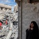An image of a woman speaking on the phone as emergency workers sift through rubble of a residential building that was hit in an airstrike in Tehran.