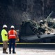 A photo of construction workers surveying highway damage