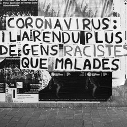 A sign in black and white denounces coronavirus-related racism in France.