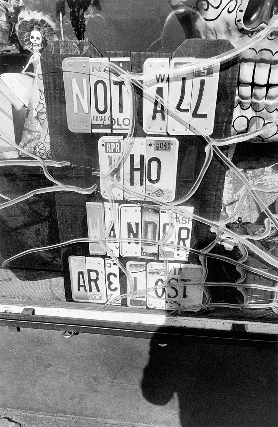 black-and-white photo of sign made of sliced-up license-plate numbers and letters