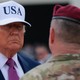 An image of President Trump and Secretary Hegseth looking at a U.S. serviceman.
