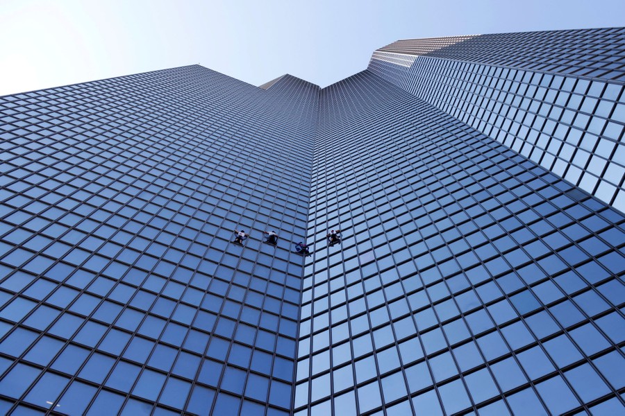 Four climbers scale the side of a skyscraper.