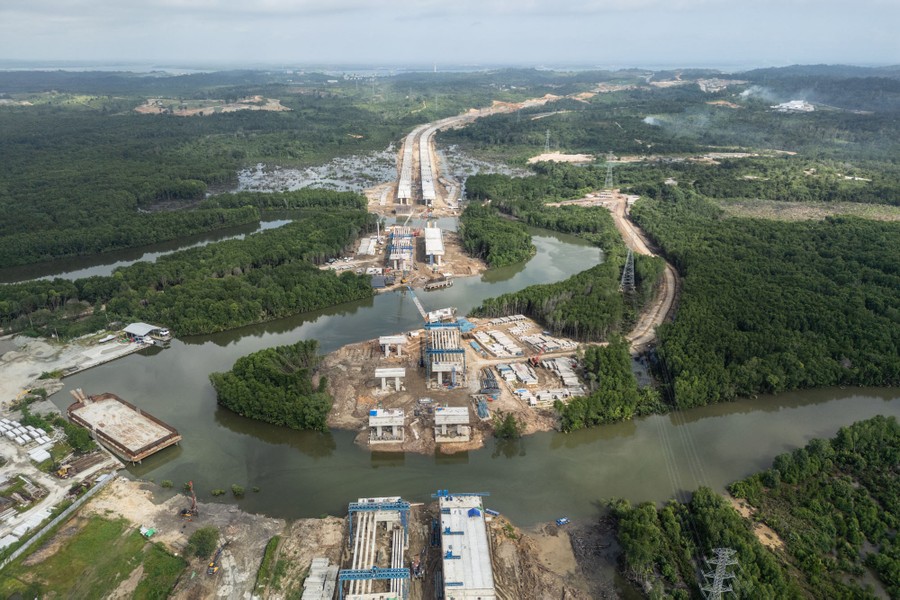 An aerial view of a highway under construction through a forested area