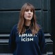 Alice Birch stands against a black wall with her hair blowing, wearing a blue sweater that reads "Romanticism."