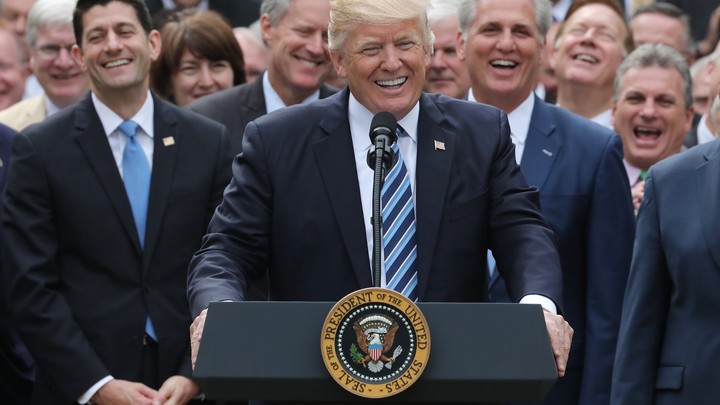 President Donald Trump celebrating in the Rose Garden surrounded by Republican congresspeople