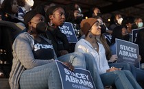 A photo of young people holding signs supporting Stacey Abrams