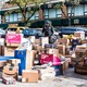 A deliveryman stands in a sea of subscription-service boxes on a sidewalk in NYC.