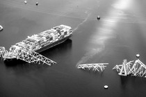 black-and-white aerial photo of the container ship Dali and the collapsed Francis Scott Key Bridge in the Patapsco River