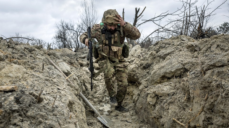 A photo of a Ukrainian soldier running through a trench