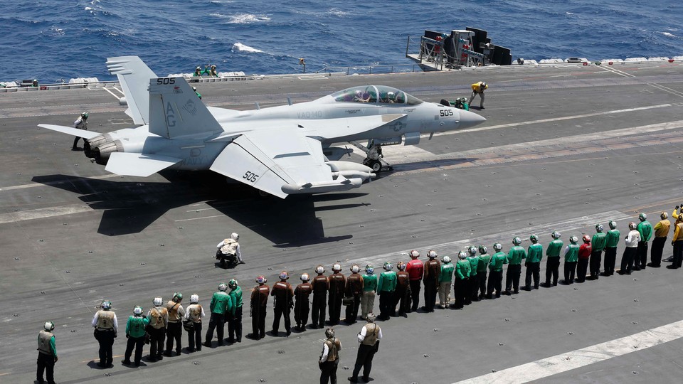 Sailors on the USS Abraham Lincoln take part in an aerial change of command ceremony in the Arabian Sea.
