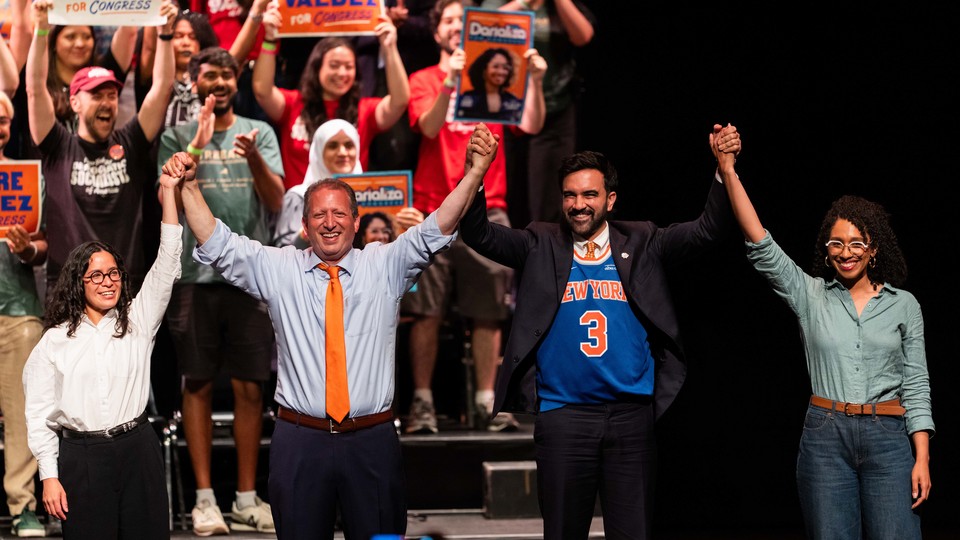 Zohran Mamdani wears a Knicks jersey and stands with the candidates he endorsed, arms raised.