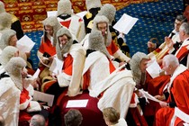 A photograph of peers, some in wigs, sitting in the chamber of the U.K. House of Lords