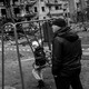 A boy plays on a swing in front of a damaged residential block in Kyiv, Ukraine.