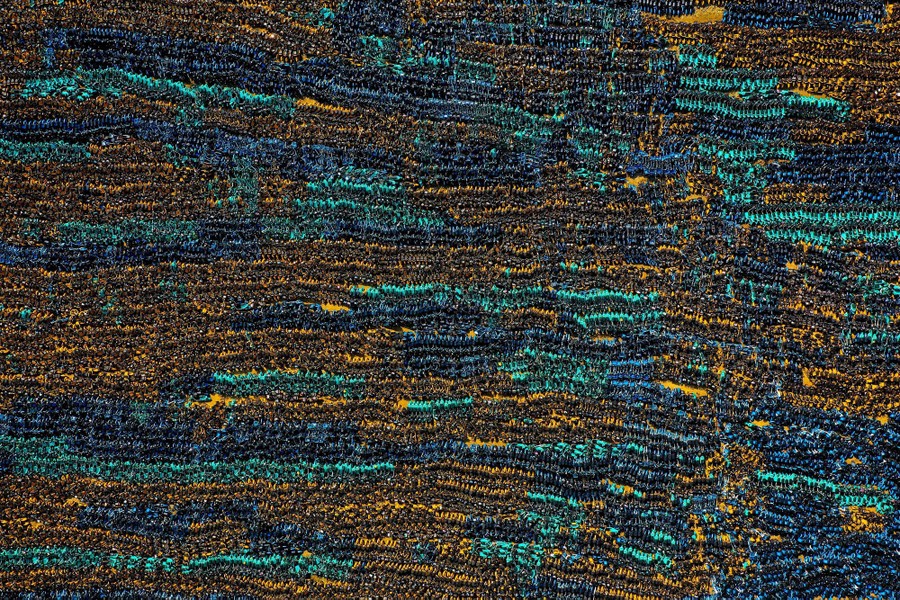 Thousands of abandoned bicycles are seen piled together in rows.