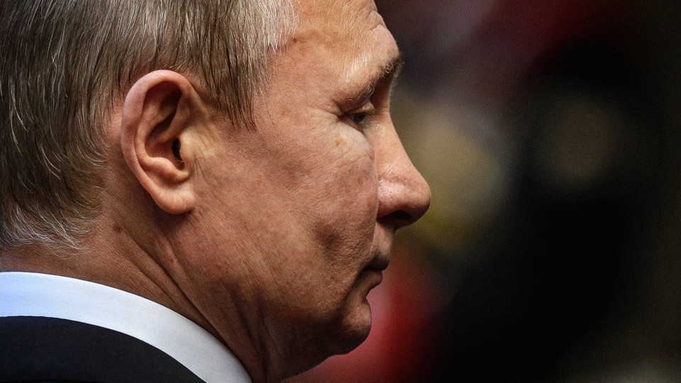 A close-up photo of Vladimir Putin's face seen from the right