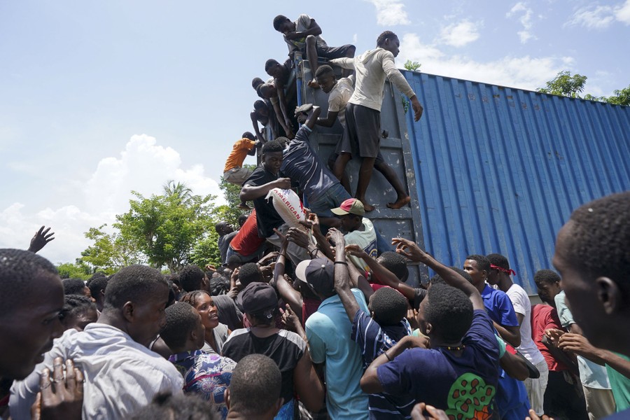 People climb onto a container truck.