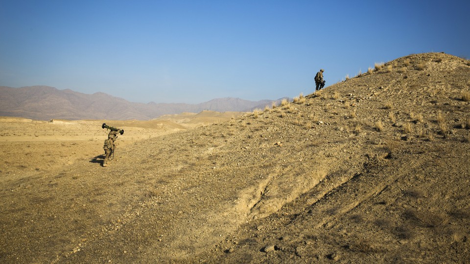 U.S. soldiers climb a hill in Afghanistan