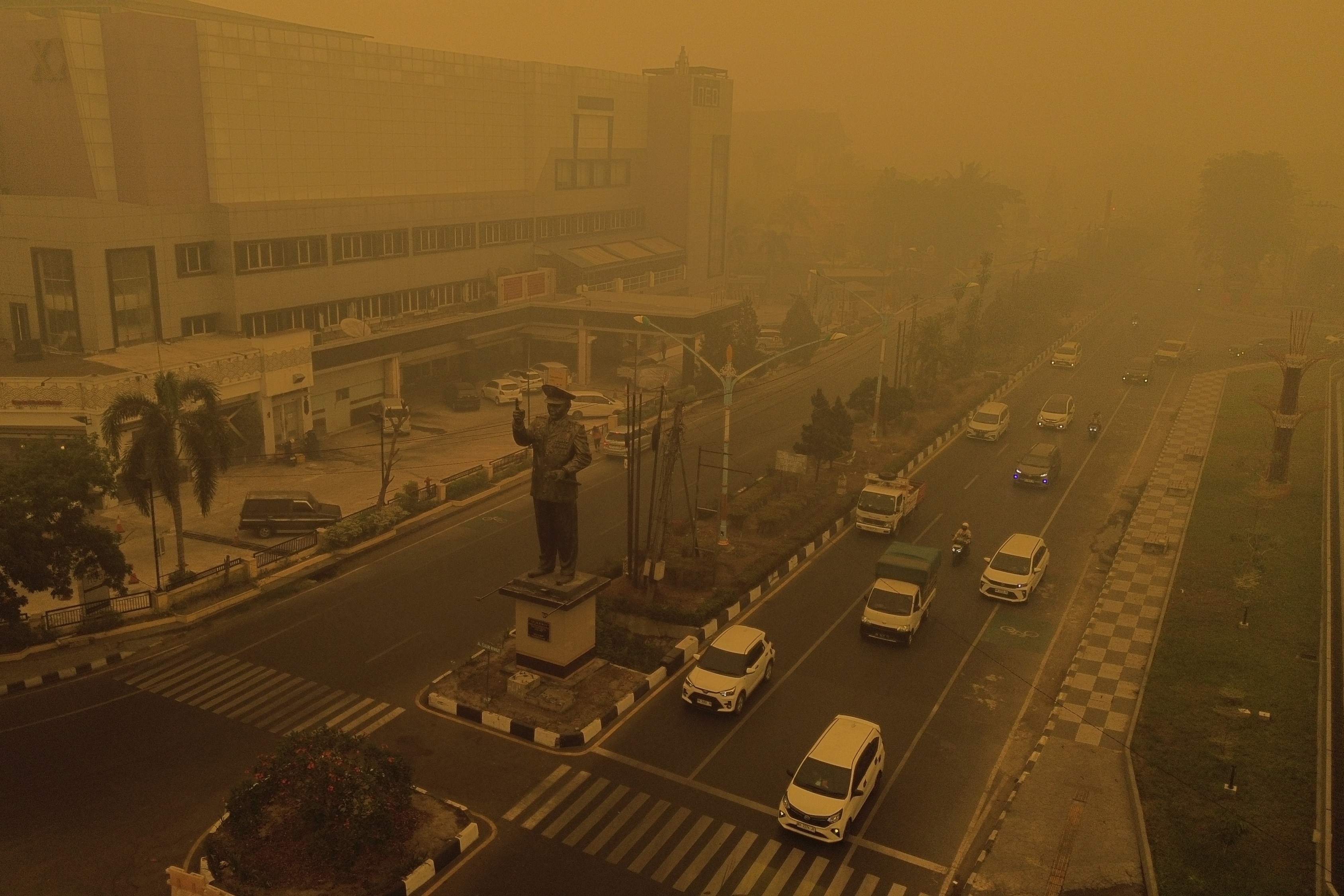 Thick smoke and haze fill the air above a city street.