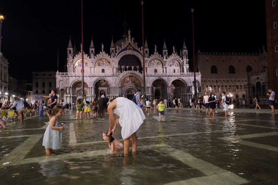 Dozens of people walk in a flooded St. Mark's Square in Venice.