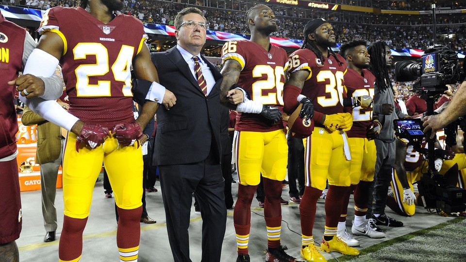The Washington football team owner Daniel Snyder stands with the players Josh Norman, Bashaud Breeland, and D.J. Swearinger during the playing of the national anthem before a game.