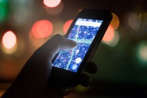 A hand holding a phone with a map open