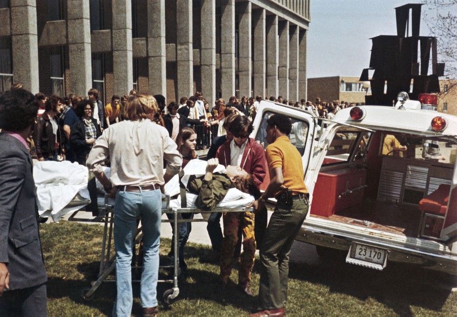 An injured student on a stretcher is wheeled to a waiting ambulance.