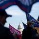 The U.S. Capitol is seen through a group of pro-Trump protesters waving flags on the streets of Washington, D.C.